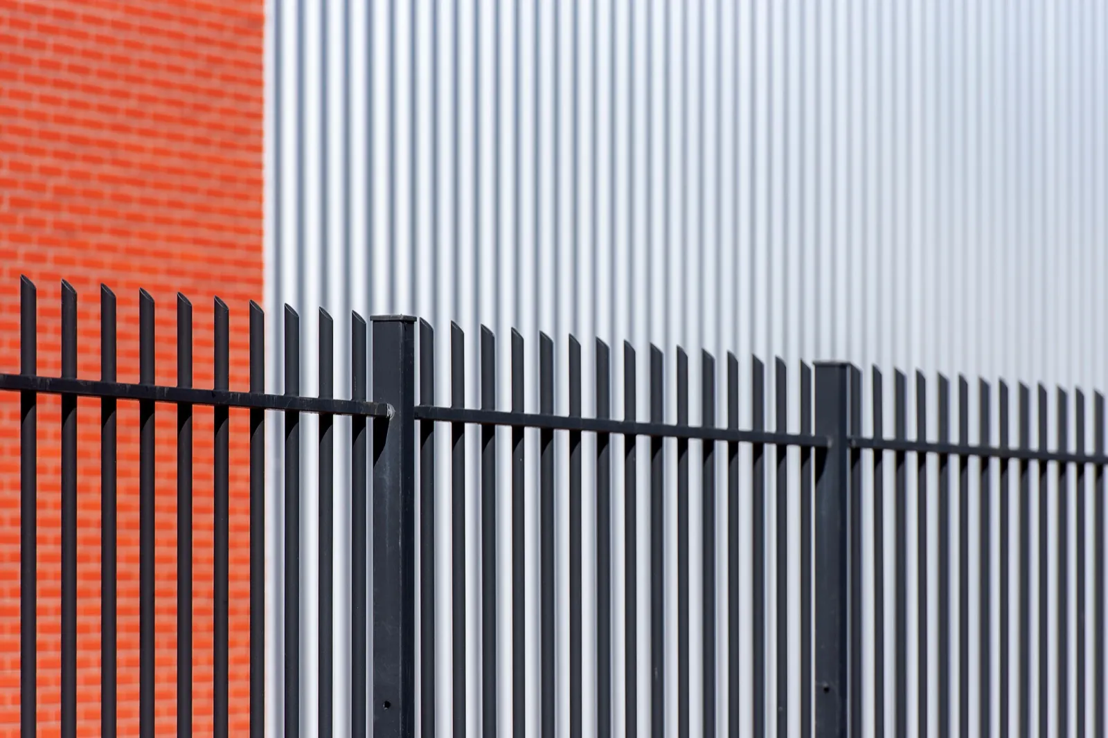 Black steel palisade security fencing against a building